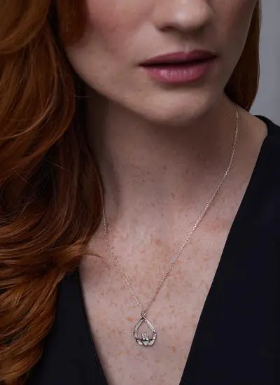Close up of red haired model wearing Sterling Silver Teardrop Claddagh Weave Pendant